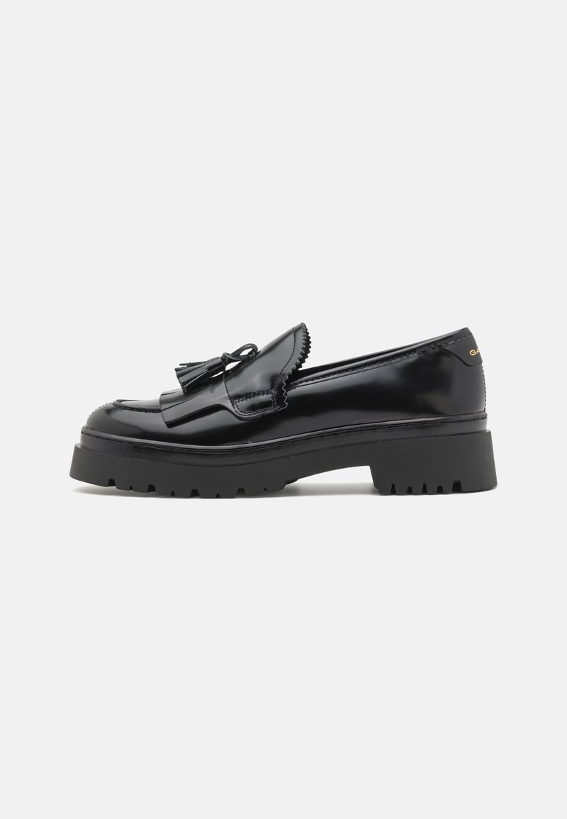 Schwarze lackierte Lederloafers mit einer robusten Gummisohle, die über ein markantes Quasten-Detail und gewellte Kanten verfügen.