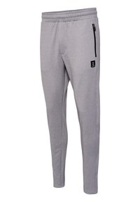 Pantaloni atletici gri, realizati dintr-un material moale, avand un croi conic, talie elastica, buzunare laterale si o mica eticheta logo neagra.