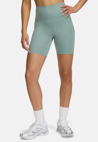 Shorts de vélo taille haute vert menthe avec une texture lisse et un design ajusté, dotés de poches latérales et de coutures plates pour plus de confort.