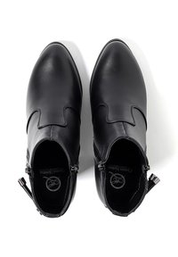 Stivaletti in pelle nera con finitura liscia, caratterizzati da un design con cuciture curve, zip laterali e punta arrotondata. Sottopiedi morbidi e texturizzati visibili.