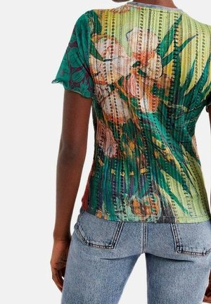 Frau trägt ein kurzärmeliges, mehrfarbig geripptes Oberteil mit Blumen- und Streifenmustern, kombiniert mit hellblauen Jeans.