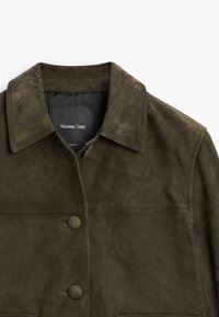 Brown suede jacket featuring a button-up front, collar, and two front pockets. Smooth texture with stitching details along the seams.