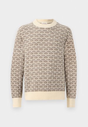 Pulover tricotat în nuanțe de crem și maro, cu un model geometric. Guler și manșete cu bordură, finisaj texturat al țesăturii și croială lejeră.