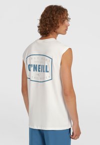 White sleeveless T-shirt featuring a blue graphic on the back with text and a logo. Made of cotton, with a relaxed fit and soft texture.