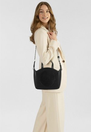 Bolso negro con diseño texturizado, que presenta un logo circular, dobles asas y una correa de hombro ajustable. Forma rectangular.