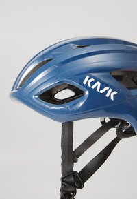 KASK cycling helmet in glossy blue with aerodynamic design, integrated ventilation holes, black adjustable straps, and white logo detail.