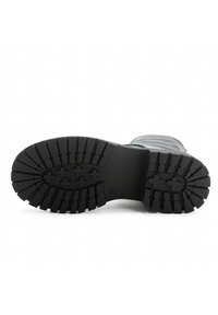 Semelle de botte en caoutchouc noir avec un motif texturé et des crampons pour une meilleure adhérence. Forme arrondie avec des bords lisses, conception robuste. Convient pour une utilisation en extérieur.