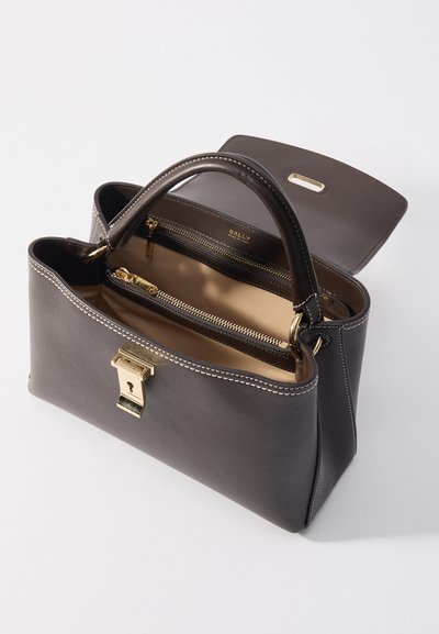 Dark gray leather handbag with a structured shape, featuring a gold hardware clasp, double handles, and a beige interior with zippered compartments.
