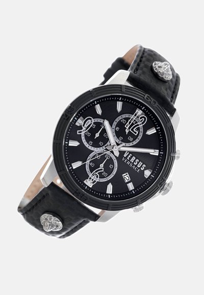 Montre chronographe noire avec des accents argentés, bracelet en cuir noir texturé, et un cadran noir comportant trois sous-cadrans et un affichage de la date.