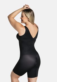 Zwarte shapewear van een gladde, rekbare stof, met een v-hals ontwerp, brede banden en korte pijpen, met een naadloze afwerking.