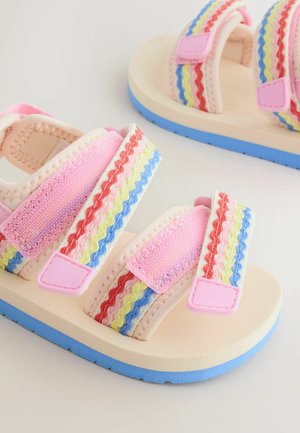 Sandali per bambini con suole beige, fondo blu e cinturini rosa con motivi ondulati rossi, gialli e blu e chiusure in velcro.