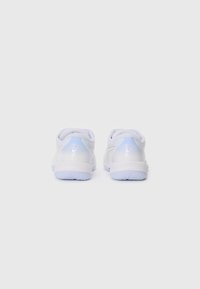 Baskets blanches de sport avec une finition lisse, une forme arrondie et des accents bleu clair sur le talon. Détail de rembourrage au niveau du col et semelle texturée.