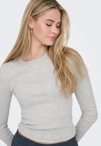 Γκρι μακρυμάνικη μπλούζα με ριμπ ύφανση και στρογγυλή λαιμόκοψη. Το ύφασμα φαίνεται απαλό και ελαφρύ, κατάλληλο για καθημερινή χρήση. Η λαιμόκοψη και τα μανίκια είναι εφαρμοστά.