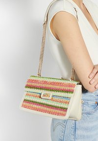 Geweven handtas in meerdere kleuren met strepen in roze, groen en blauw, met een witte faux-lederen basis en een gouden kettingriem.