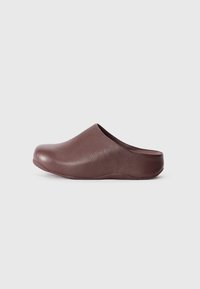 Sabots en cuir marron avec une texture lisse, un bout arrondi et une semelle basse et profilée. Dispose d'un design sans arrière pour un enfilage facile.