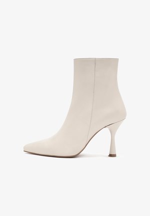 Stivale alla caviglia in pelle bianca con punta affusolata, design elegante e tacco a spillo distintivo. Texture liscia con dettagli di cucitura minimi.