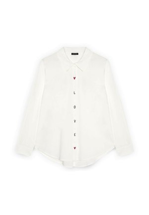 Witte blouse met lange mouwen en knopen, voorzien van een kraag, met verticale "LOVE" letters en rode hartjes langs de knopenlijst.