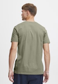 Olive green short-sleeve t-shirt made of cotton, featuring a classic crew neck and a relaxed fit, with a smooth, soft texture.