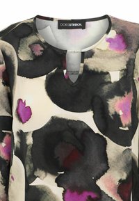 Bluse mit Blumenmuster und Keyhole-Ausschnitt, in Schwarz, Creme und Rosa, aus glatter Stoff mit leichtem Glanz.