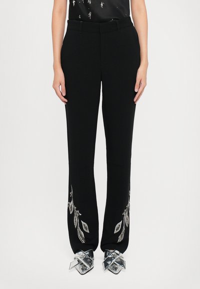 Pantalones negros con diseño de frente plano, que presentan bordados de hojas plateadas a lo largo de los dobladillos. Fabricados en una tela suave, de corte ajustado y con bolsillos.