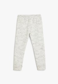 Leggings de color gris claro, hechos de un tejido suave y texturizado con un patrón salpicado. Cuentan con una cintura elástica para mayor comodidad y flexibilidad.