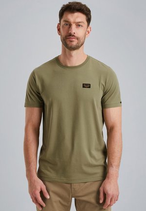 T-shirt olive vert à col ras du cou, manches courtes, en coton avec une texture lisse, comportant un petit patch logo en tissu noir sur la poitrine.