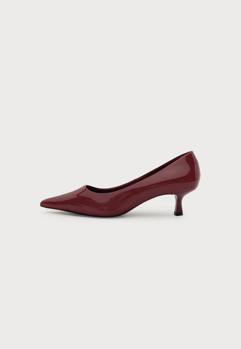Escarpin femme en cuir verni rouge foncé brillant, bout pointu avec un petit talon kitten, sur fond blanc uni.