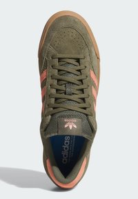 Πράσινο σουέντ αθλητικό παπούτσι με ροζ ρίγες, γλώσσα από δίχτυ και καουτσούκ σόλα. Διαθέτει κορδόνια, ετικέτα με λογότυπο και επένδυση μπλε πάτου με μαξιλαράκι.