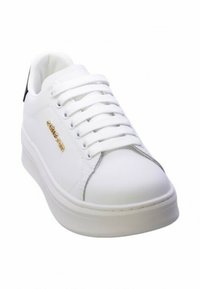 Sneaker bianca con esterno in pelle liscia, lacci piatti, logo dorato di lato e suola in gomma con una leggera piattaforma.