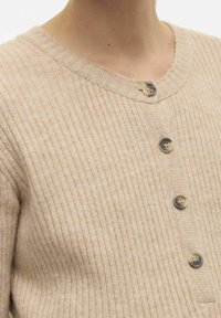 Cardigan beige à côtes avec un col rond, comportant cinq boutons foncés, une texture douce et une coupe ajustée.