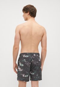 Pánske čierne plavky s multicolor grafickými vzormi. Obsahujú elastický pás a zadnú vrecko, vyrobené z rýchloschnúceho materiálu.