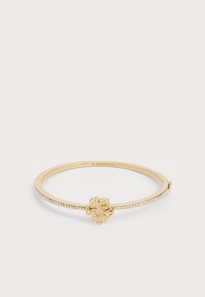 Bracelet jonc doré avec un motif floral central et une rangée de cristaux sur un côté. Fini lisse, légère texture sur le bracelet.