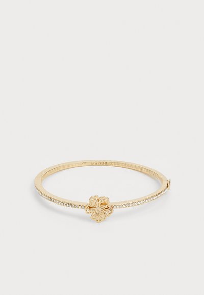 Bracciale rigido dorato con un motivo floreale al centro e una fila di cristalli lungo un lato. Finitura liscia, leggero texture sulla fascia.