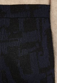 Material texturat cu dungi bleumarin și negre, având o strălucire subtilă. Designul include un amestec de linii orizontale și verticale.