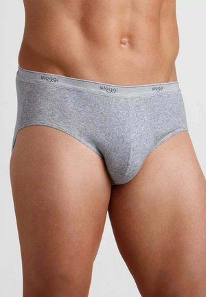 Uomo che indossa slip Sloggi grigio chiaro con fascia in vita marchiata, mostrando il torso dalla zona media alla parte superiore delle cosce su sfondo uniforme.