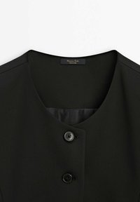 Schwarzer, strukturiert Blazer mit V-förmigem Ausschnitt. Verfügbar mit zwei schwarzen Knöpfen und einem glatten Innenfutter. Etikett ist innen sichtbar.