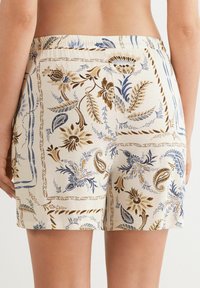 Lichte stoffen shorts met een bloemenpatroon in blauw en bruintinten. Elastische tailleband, midden-ijn lengte en rechthoekige vorm.