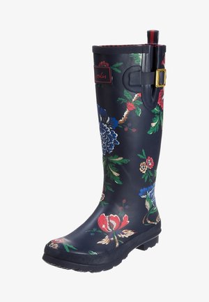 Wysoki, granatowy kalosz z wzorami kwiatowymi w kolorach czerwonym, niebieskim, zielonym i beżowym, z boczną klamrą i naszywką z logo u góry.
