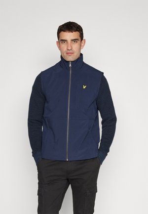 Chaleco azul marino con un cuello alto, cierre frontal y una manga con un patrón texturizado. Presenta un pequeño logo amarillo en el pecho.