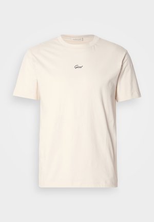 Cremefarbendes Baumwoll-T-Shirt mit kurzen Ärmeln und rundem Ausschnitt. Mit kleinem schwarzen bestickten Logo auf der Brust. Weicher Stoff.