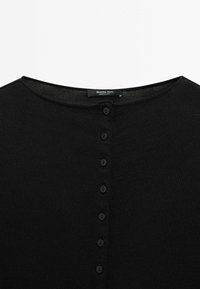 Cardigan noir en maille avec un col rond et une rangée de sept petits boutons noirs au centre devant, fabriqué par Massimo Dutti.