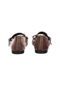 Zapatos de terciopelo marrón con acentos de cuero, punta redondeada y correa ajustable con herrajes dorados. Suela de goma negra, diseño plano.