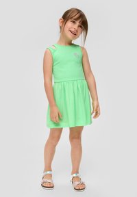 Grünes Baumwollkleid ohne Ärmel mit tailliertem Oberteil und schwingendem Rock. Es hat ein kleines Erdbeer-Graphic und Ausschnittdetails an den Schultern.