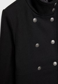 Cappotto in misto lana nero con colletto alto, dotato di sei bottoni metallici sul davanti e tessuto testurizzato sulla superficie.