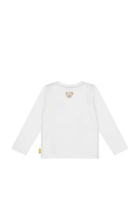 Camicia bianca a maniche lunghe realizzata in cotone, con una toppa a forma di faccia di orso sulla parte superiore della schiena e cuciture a contrasto lungo le cuciture.