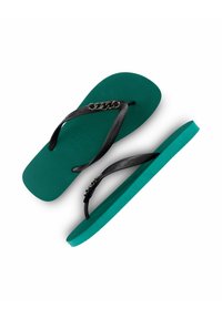 Tongs vertes avec des sangles noires présentant un motif de chaîne. Semelle en caoutchouc texturé, profil plat et couleurs contrastantes.