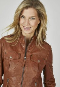 Braune Lederjacke mit hohem Kragen, Reißverschluss und zwei vorderen Taschen mit Druckknöpfen. Glatte Textur mit feinen Steppdetails.