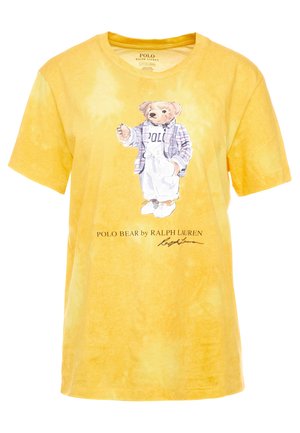Keltainen värjätty t-paita, jossa pukeutunut karhu ruudullinen bleiseri päällä, valkoiset housut ja lenkkarit, alla teksti "POLO BEAR by RALPH LAUREN".
