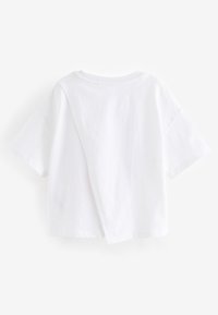 Hvid t-shirt med korte ærmer i bomuld og en afslappet pasform, med en slids på ryggen for en lagdelt effekt.