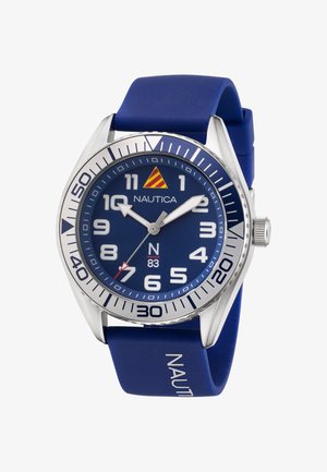 Kék Nautica óra szilikon szíjjal, kerek ezüst tok, nagy fehér számokkal ellátott számlap és ezüst kiegészítők. Piros másodpercmutatóval és logóval rendelkezik.
